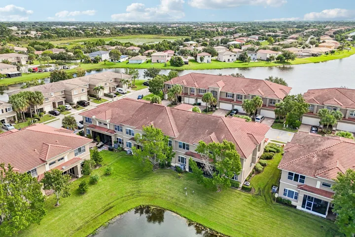 Residential community with tile roofs, manicured lawns, and water features