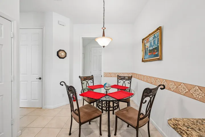 Tile flooring, pendant lighting, white paneled doors, and a decorative wall border
