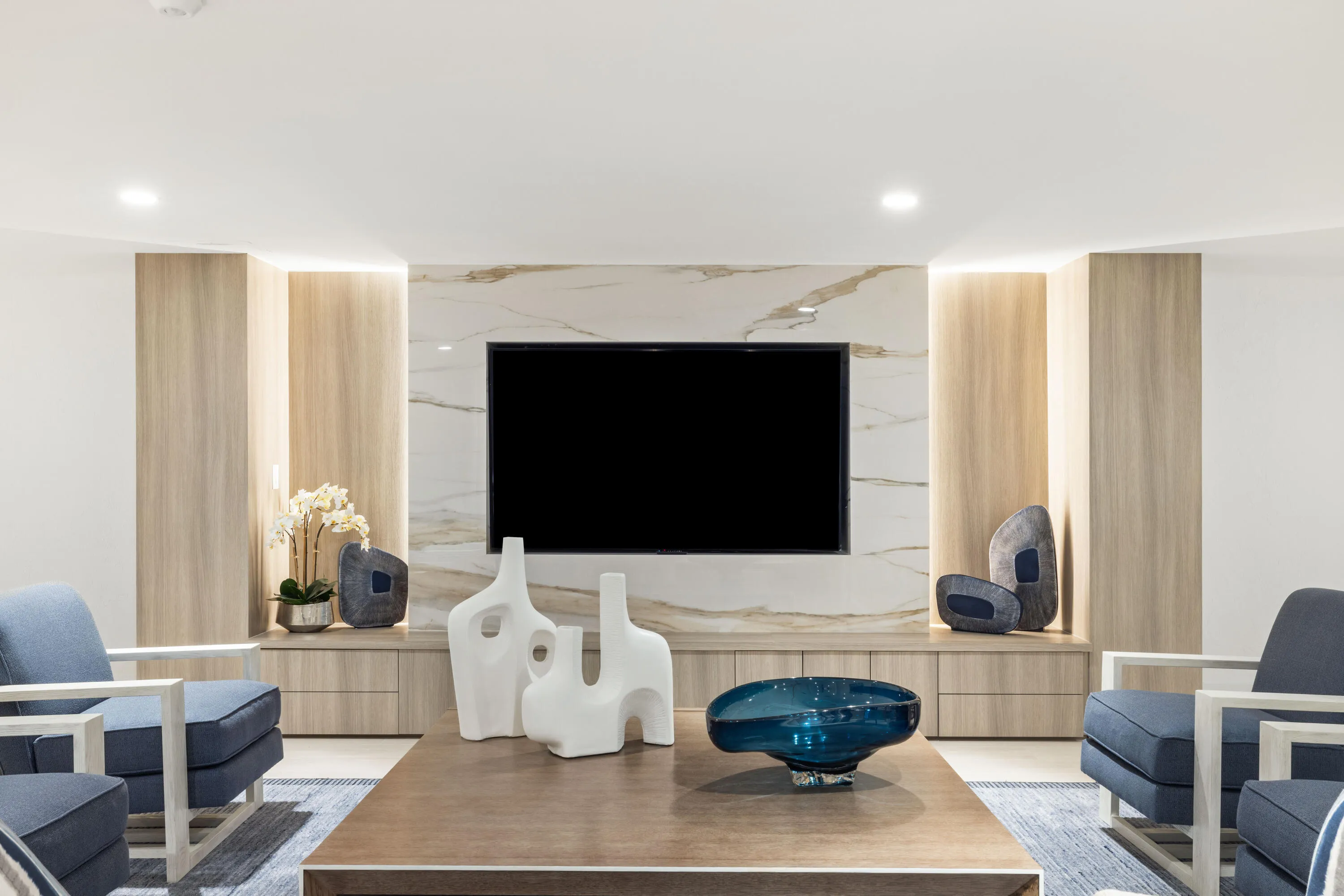 Built-in media console with wood-finish cabinetry, integrated shelving, and a stone-look accent wall