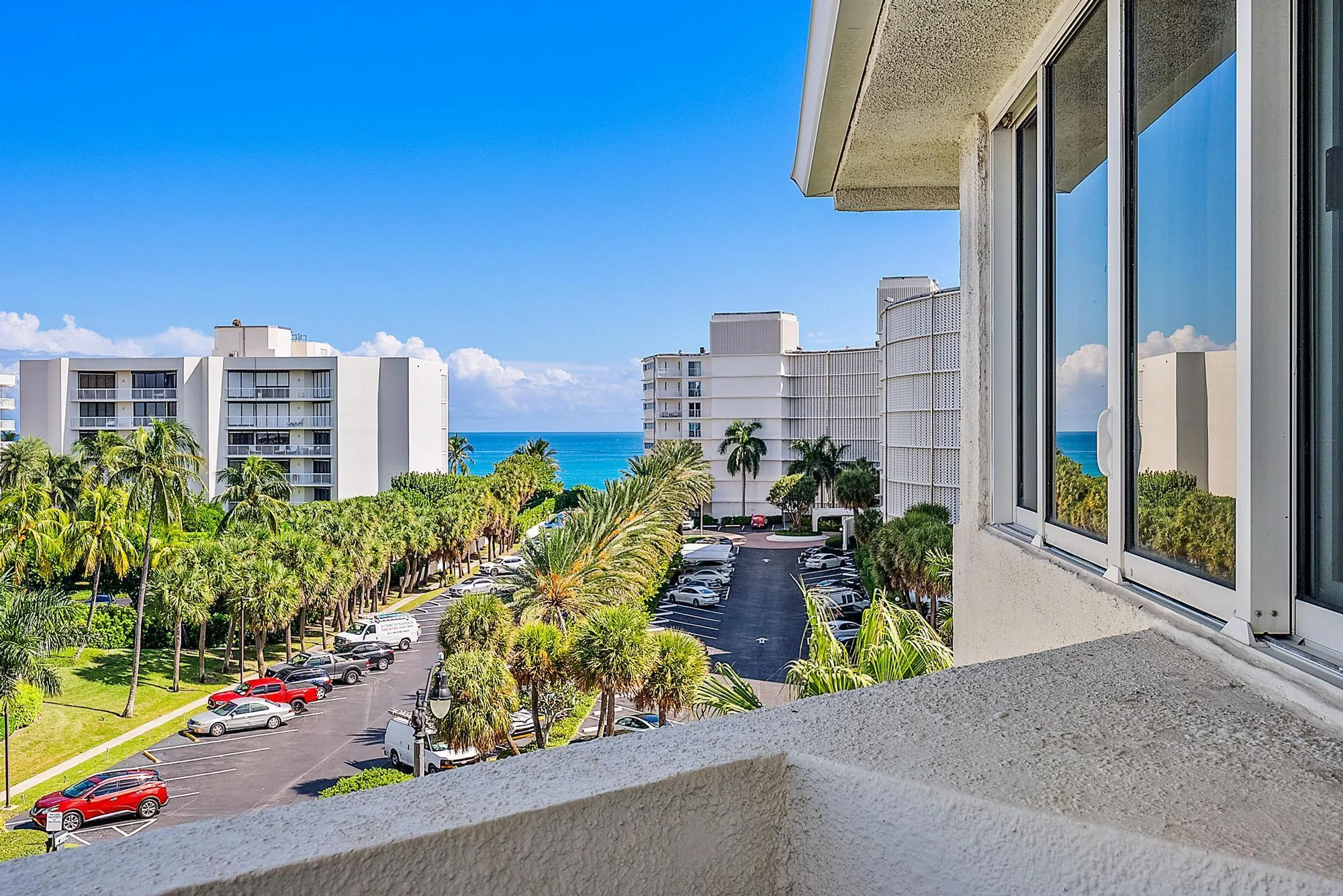 Expansive water body, lush palm trees, and clear blue sky visible from the property