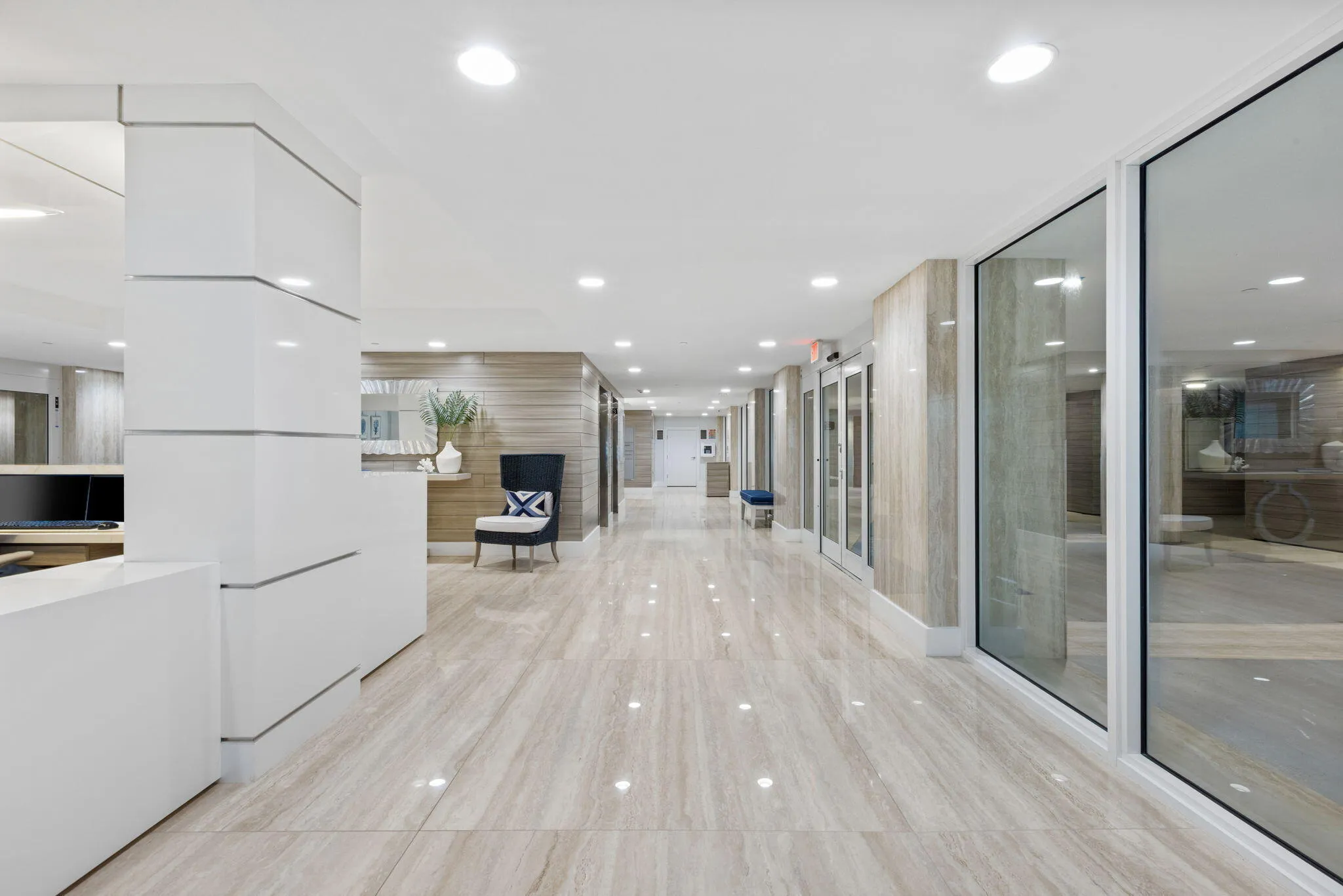 Reflective tiled flooring, recessed lighting, wood-finish wall panels, and full-height glass partitions