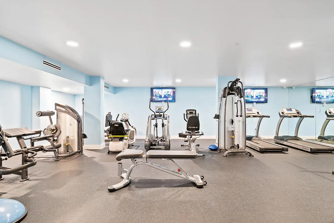 Fitness room featuring recessed lighting, light blue walls, and rubberized flooring
