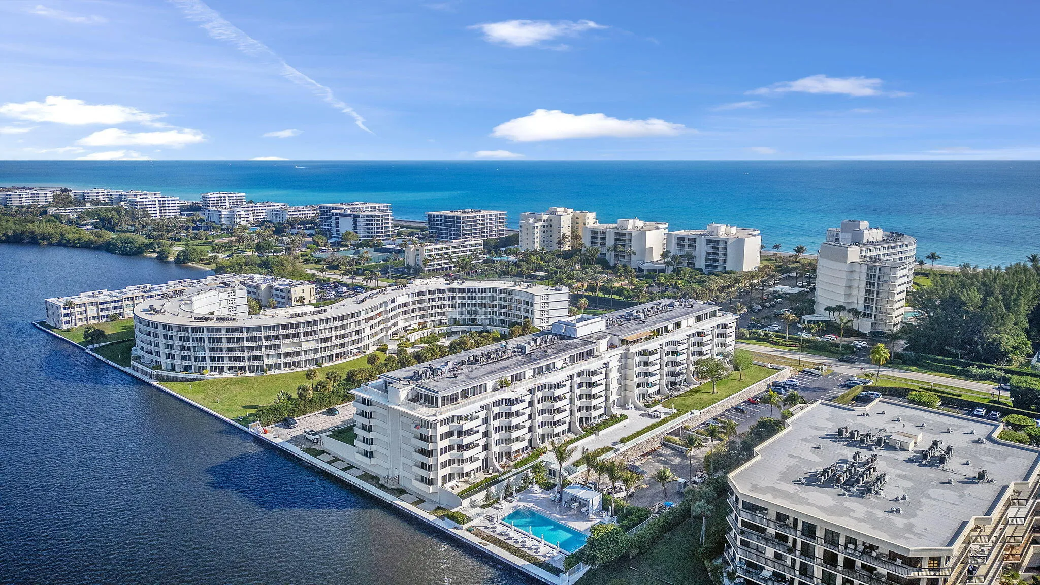 Waterfront property with multiple residential buildings, outdoor swimming pool, and direct access to a large body of water