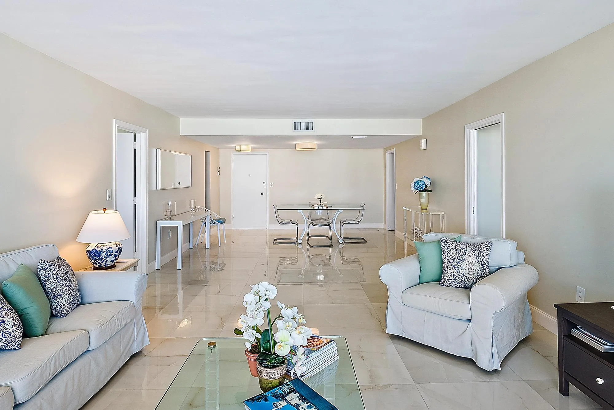 Expansive open-concept living space with polished tile flooring, recessed lighting, and neutral wall tones