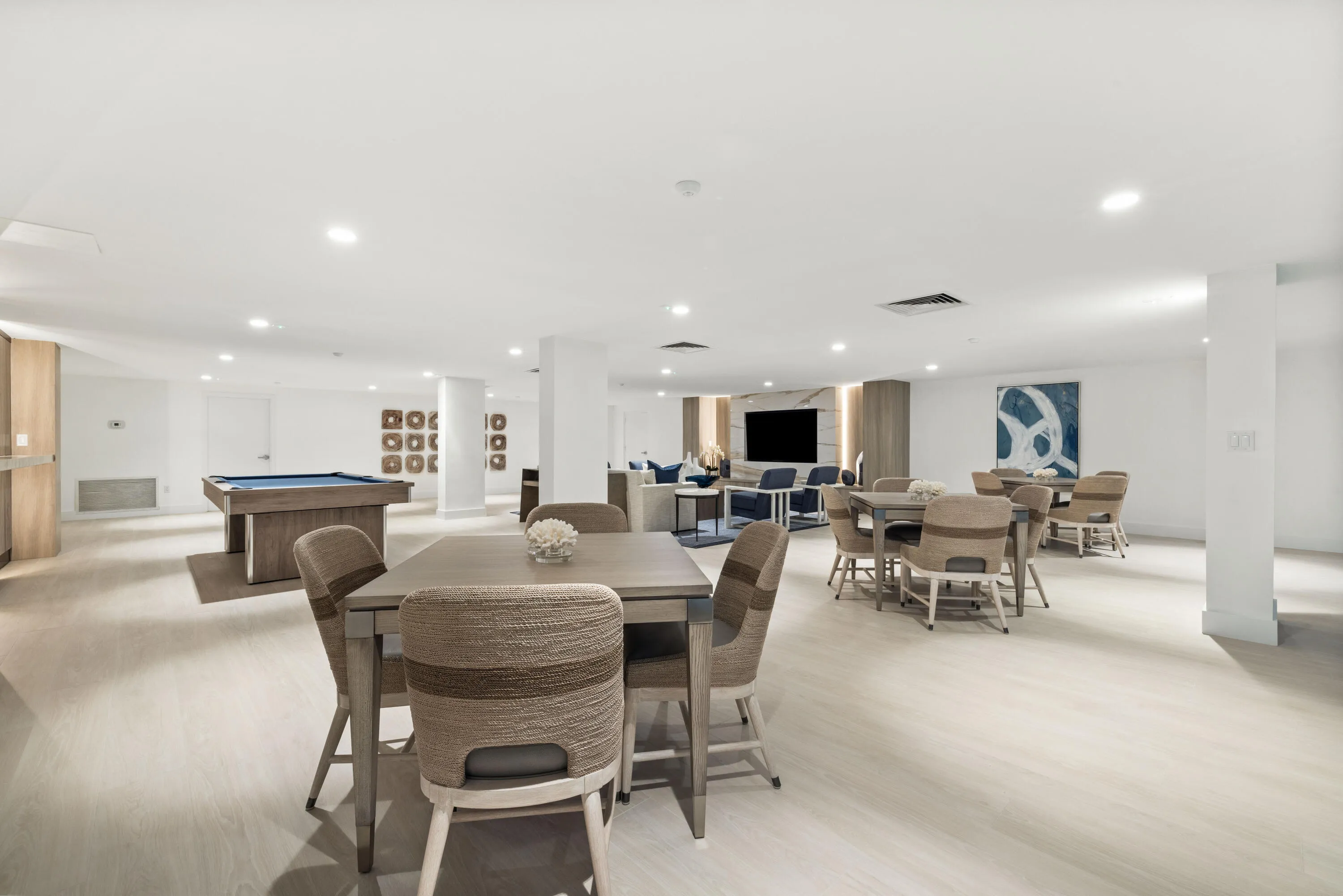 Spacious communal area featuring recessed lighting, light wood-finish flooring, a billiards table, and multiple seating areas