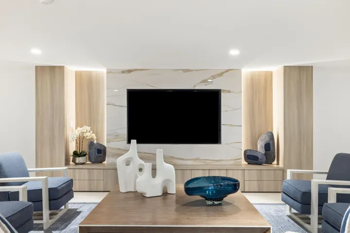 Built-in media console with wood-finish cabinetry, integrated shelving, and a stone-look accent wall