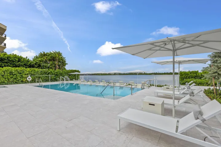 Outdoor swimming pool with integrated steps, surrounded by a stone paver deck