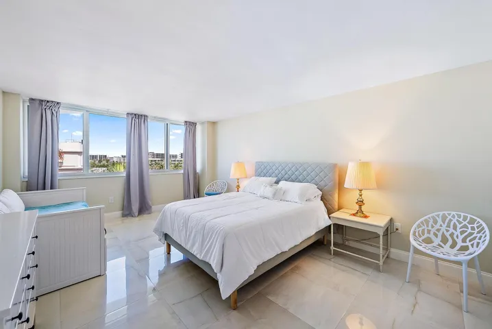 Expansive windows with city backdrop, light-toned walls, and large format tile flooring