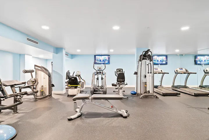 Fitness room featuring recessed lighting, light blue walls, and rubberized flooring