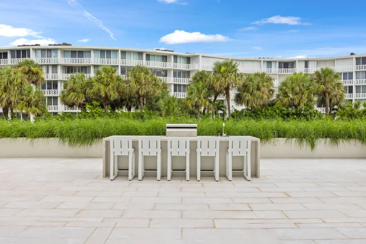 Outdoor patio featuring a built-in bar with seating for six, integrated grill, and paver flooring