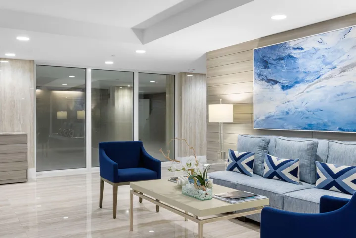 Recessed lighting, large format tile flooring, a horizontal wood-finish accent wall, and expansive glass panels