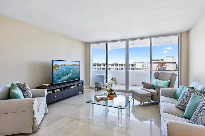 Expansive glass sliding doors to balcony, light-toned wall color, and polished tile flooring