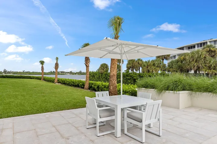Expansive patio featuring a square umbrella and a rectangular table