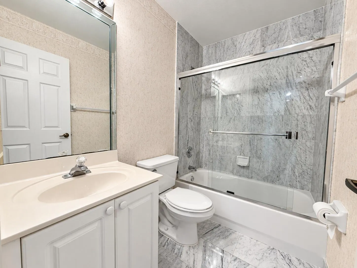 White vanity with integrated sink, chrome faucet, and mirrored medicine cabinet