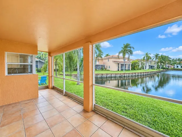 Screened outdoor living area with tiled flooring, a built-in sink, and water frontage