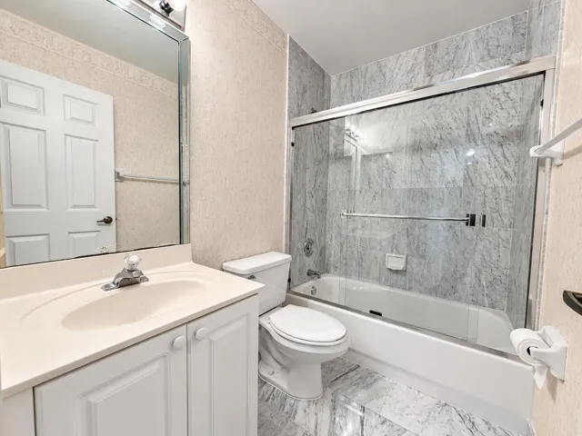 White vanity with integrated sink, chrome faucet, and mirrored medicine cabinet