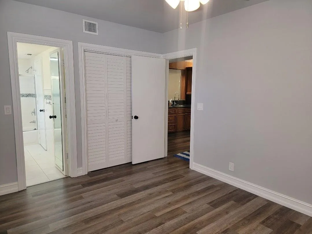 Wood-finish flooring, light gray wall paint, and white trim