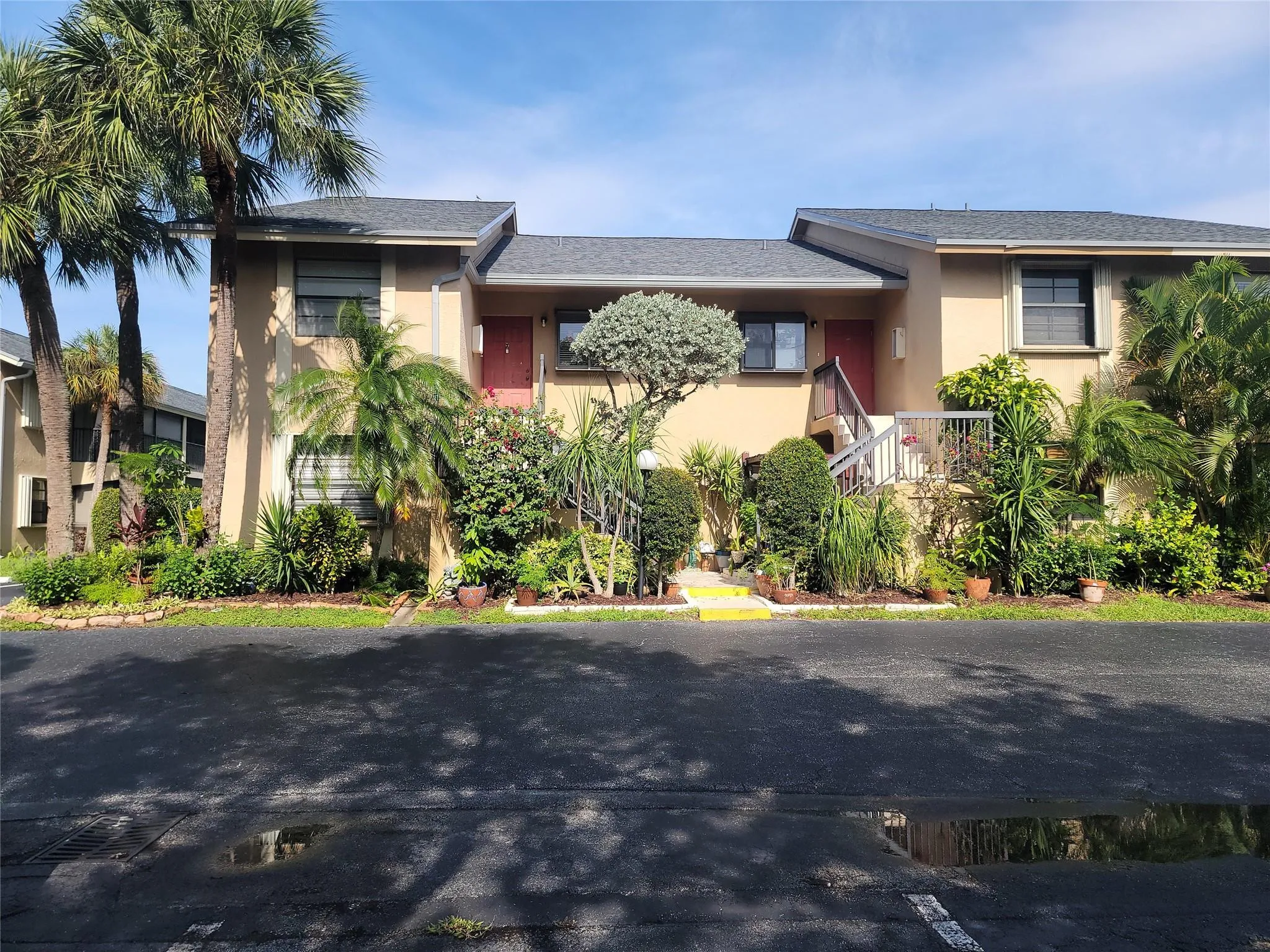 Two-story stucco exterior with dual entryways, each featuring a staircase and front door
