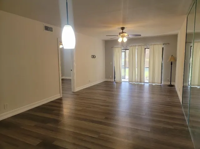 Wood-finish flooring throughout, complemented by a ceiling fan with integrated lighting