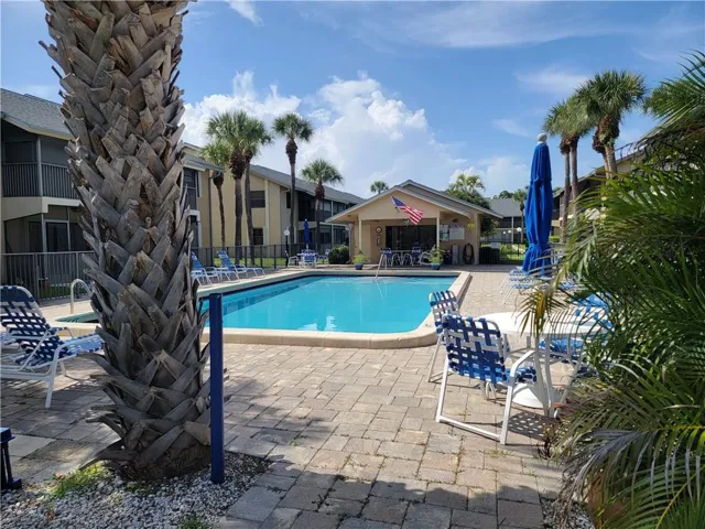 Outdoor swimming pool with integrated spa and surrounding paver patio