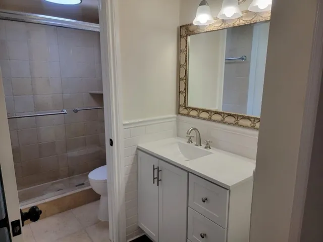 White shaker vanity with brushed nickel hardware, integrated sink, and white countertop
