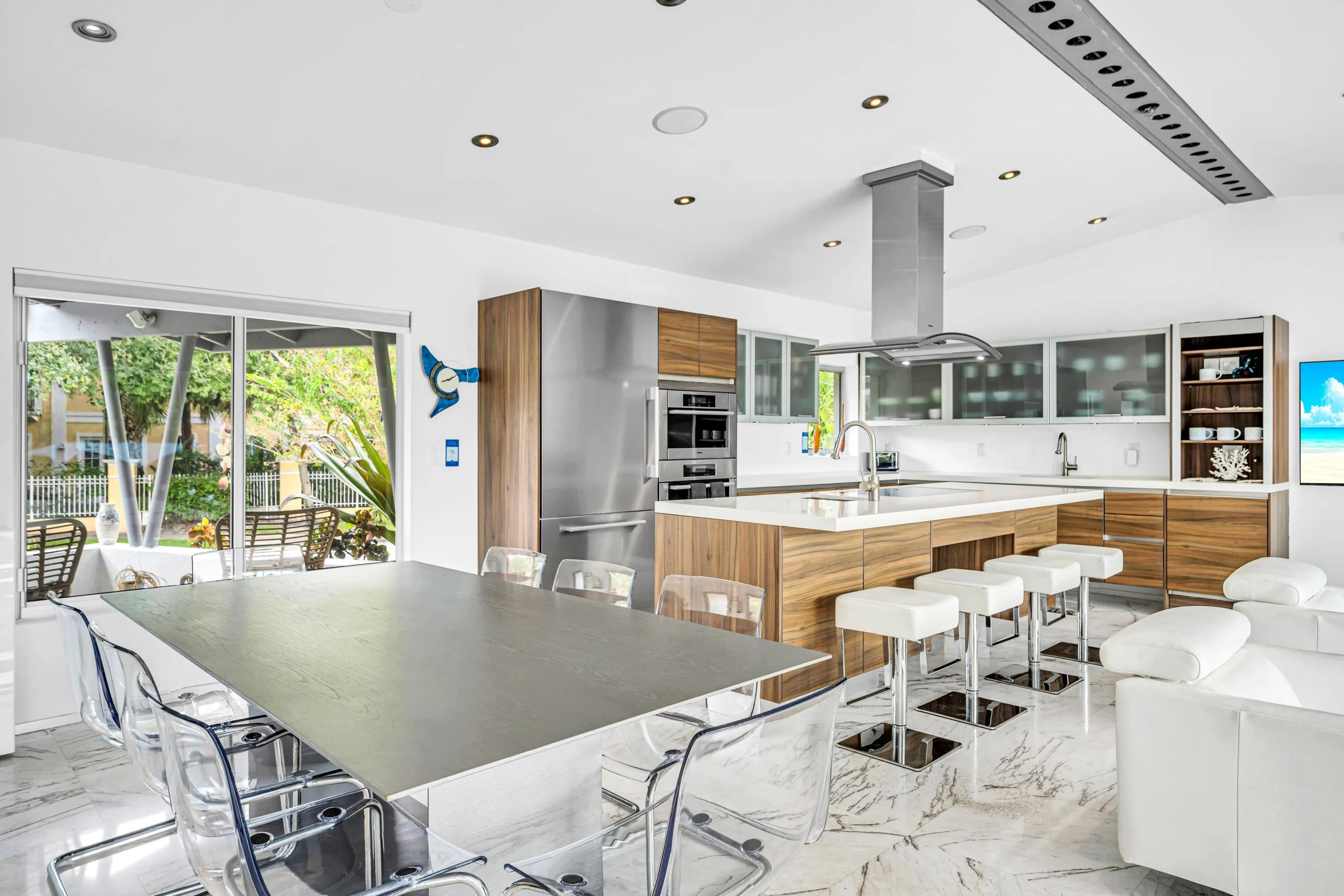 Open-concept kitchen with wood-finish cabinetry, stainless steel appliances, and a central island with a sink