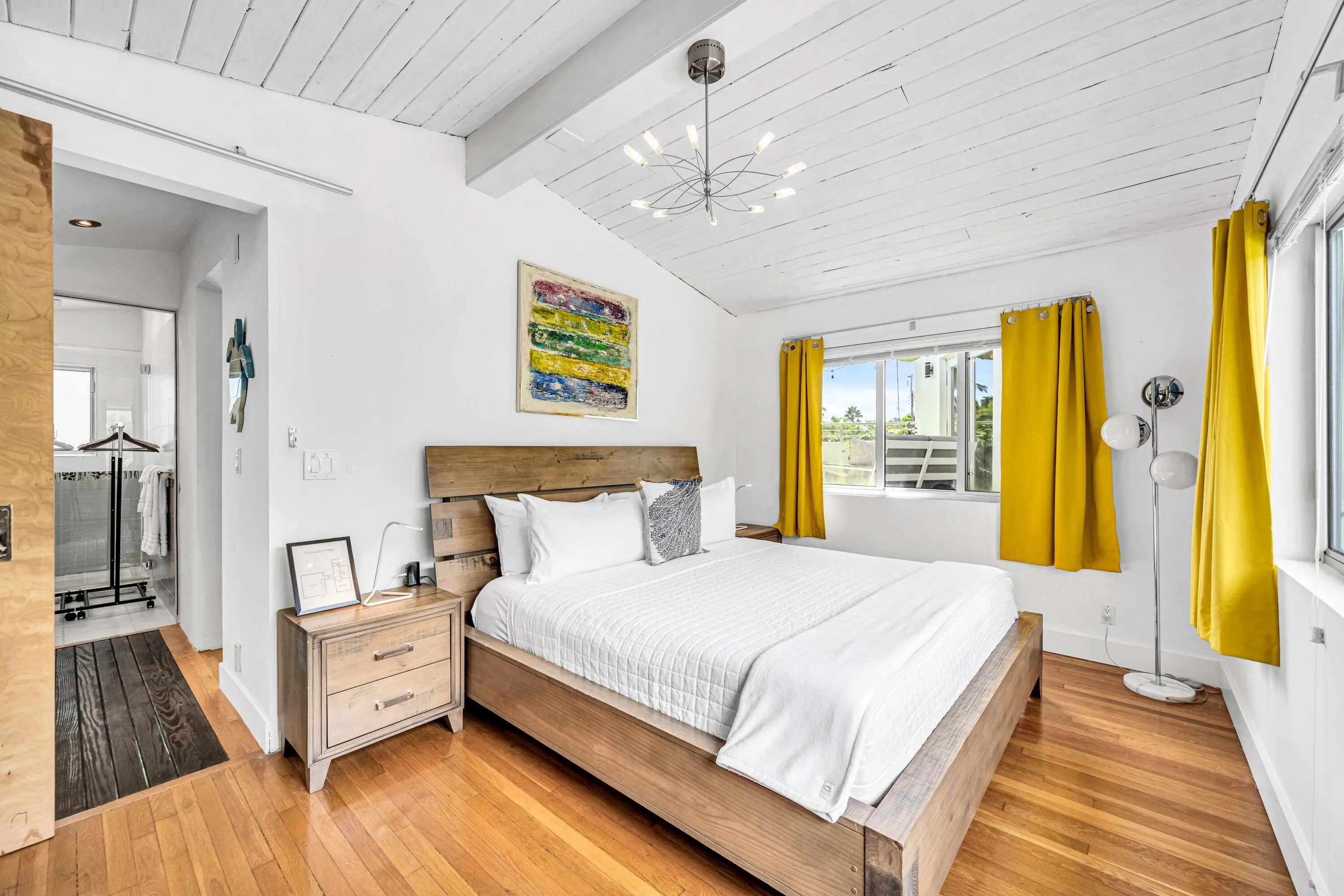 Vaulted wood-plank ceiling, wood-finish flooring, large window, and modern chandelier