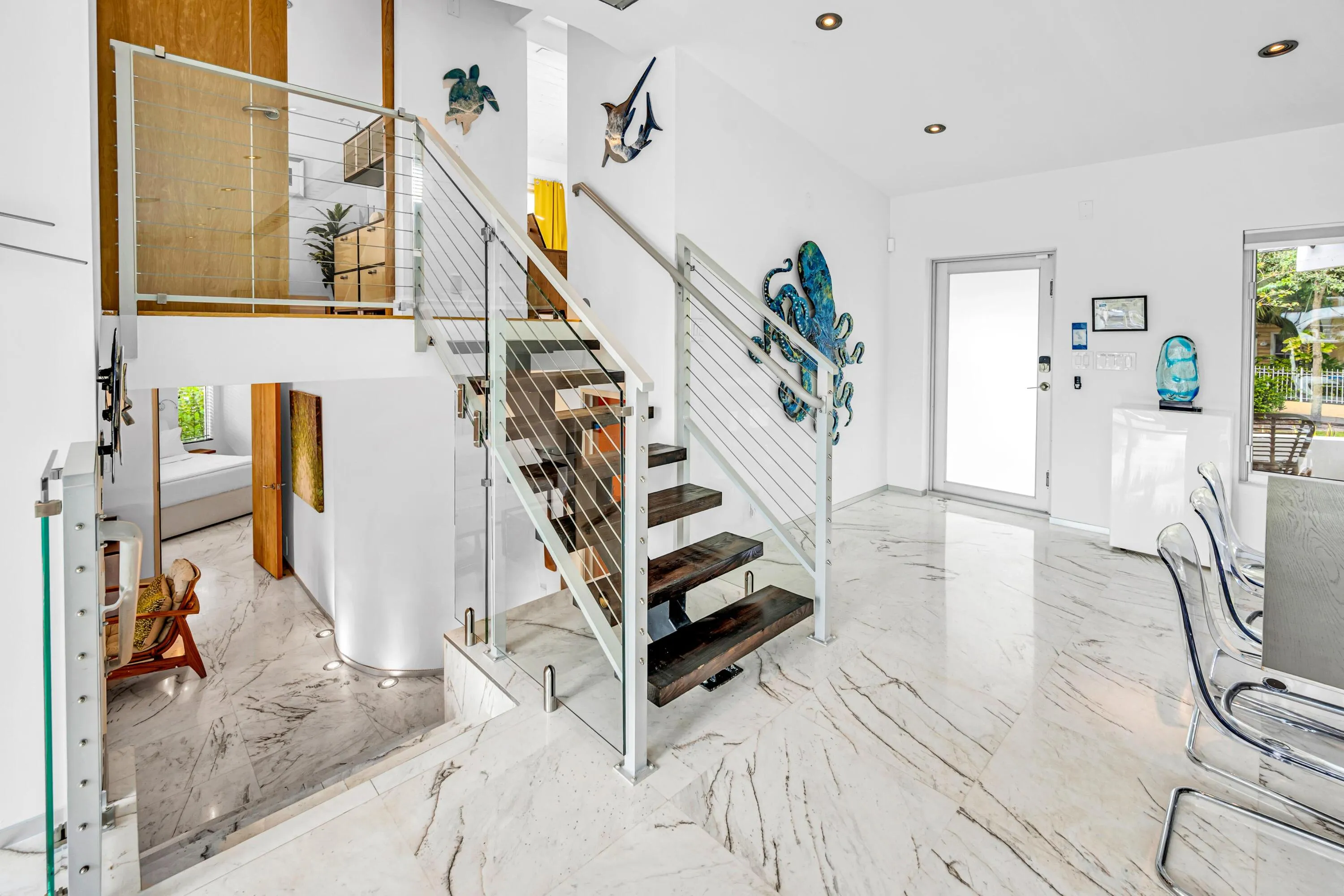 Modern staircase featuring wood treads, glass panels, and stainless steel railings