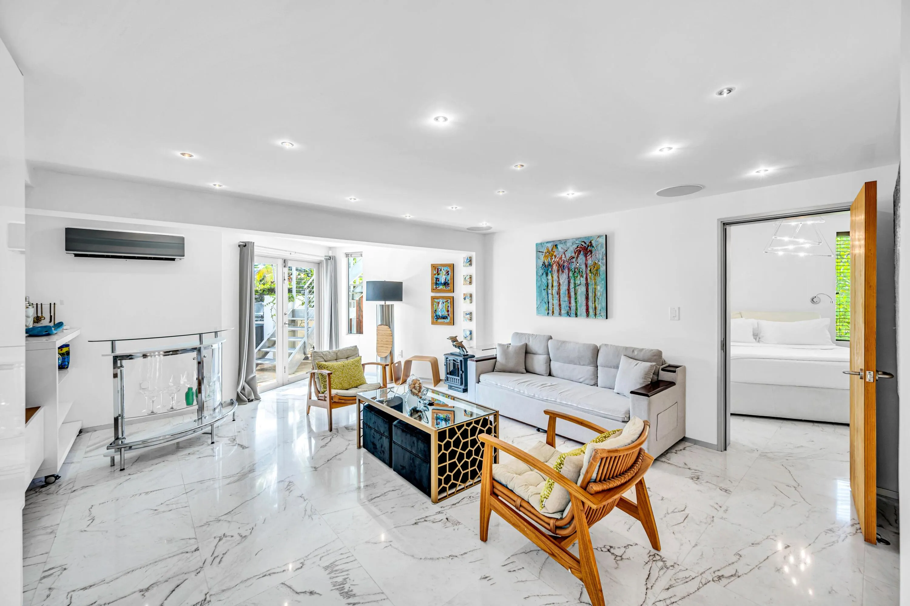 Recessed lighting, large format stone-finish tile flooring, wall-mounted air conditioning unit, glass sliding doors, and a wood door frame