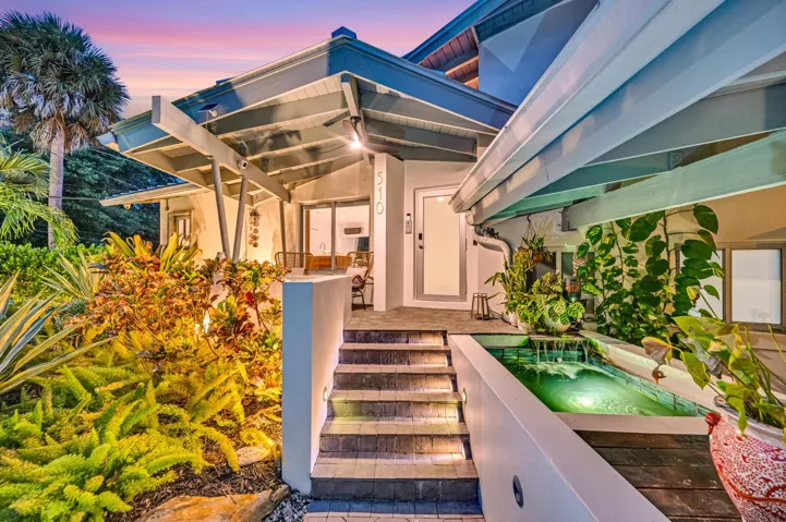 Architectural entry with an open-beam portico and a white stucco facade