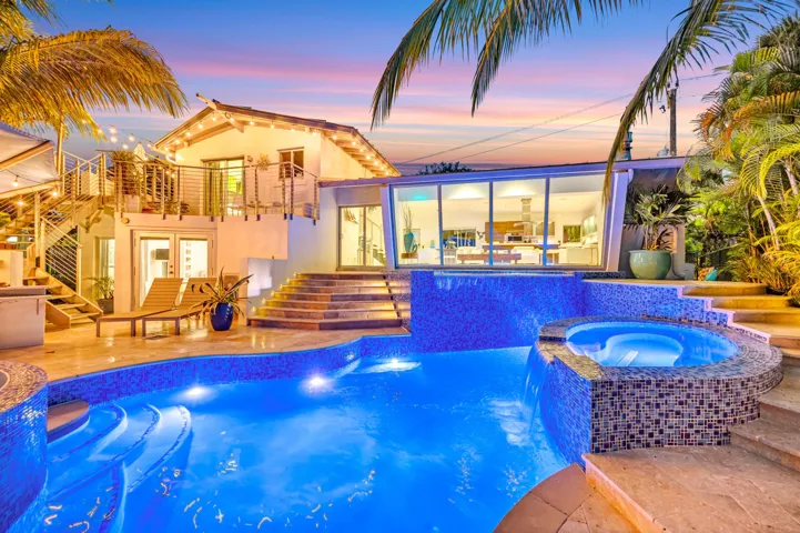 Multi-level outdoor living space featuring a custom pool, integrated spa, and expansive patio