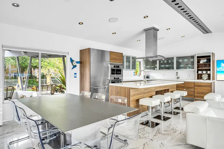 Open-concept kitchen with wood-finish cabinetry, stainless steel appliances, and a central island with a sink