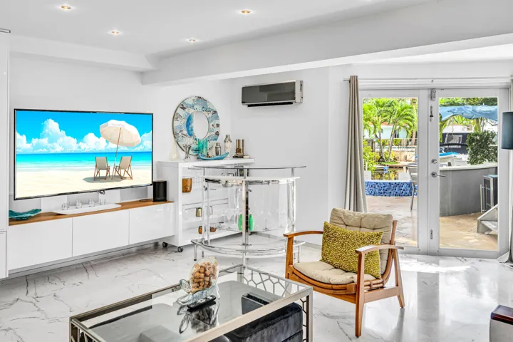 Recessed lighting, sleek white cabinetry, and large format marble-look flooring