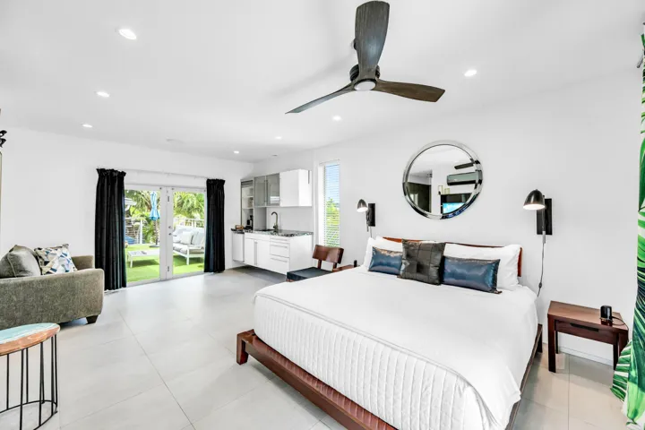 Recessed lighting, ceiling fan, white cabinetry with integrated sink, glass French doors, and a manicured lawn