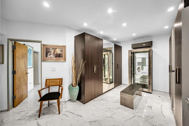 Recessed lighting, white walls, wood-finish flooring, built-in dark wood cabinetry, and a display cabinet with glass doors
