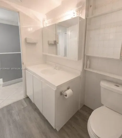 Upstairs bathroom featuring a spacious vanity, large mirror, built-in shelving, and a bright, clean layout.