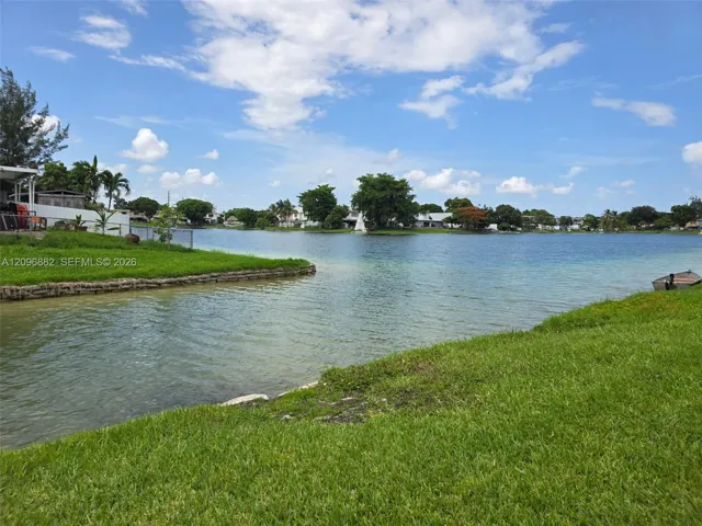 Beautiful waterfront setting featuring expansive lake views, lush green space, and direct access to the water from the property.