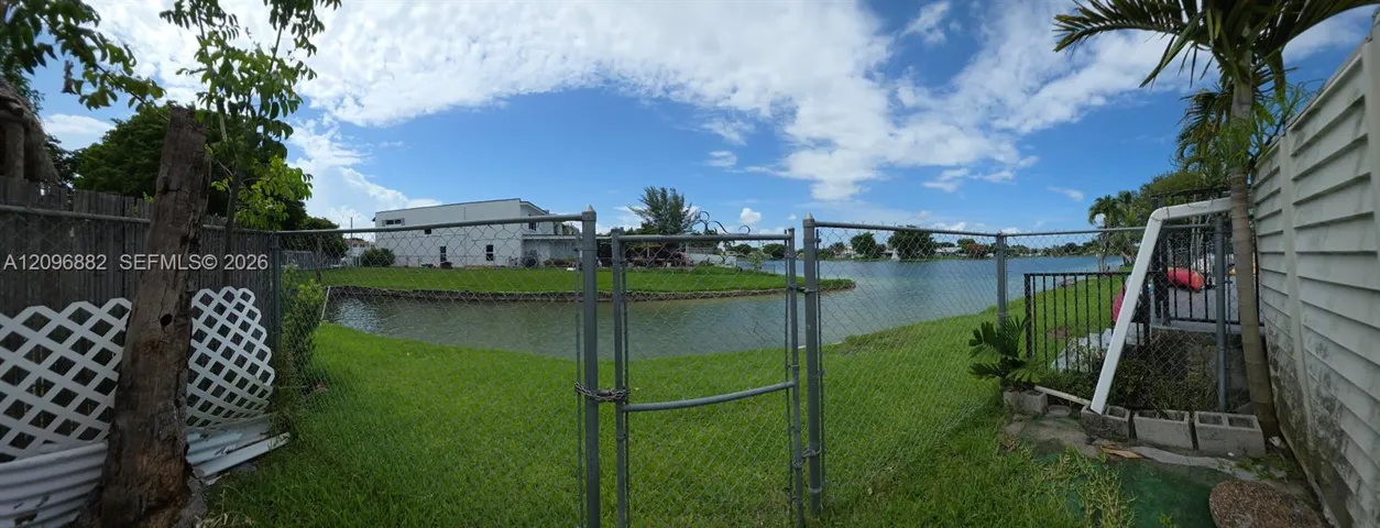 Beautiful waterfront setting featuring expansive lake views, lush green space, and direct access to the water from the property.