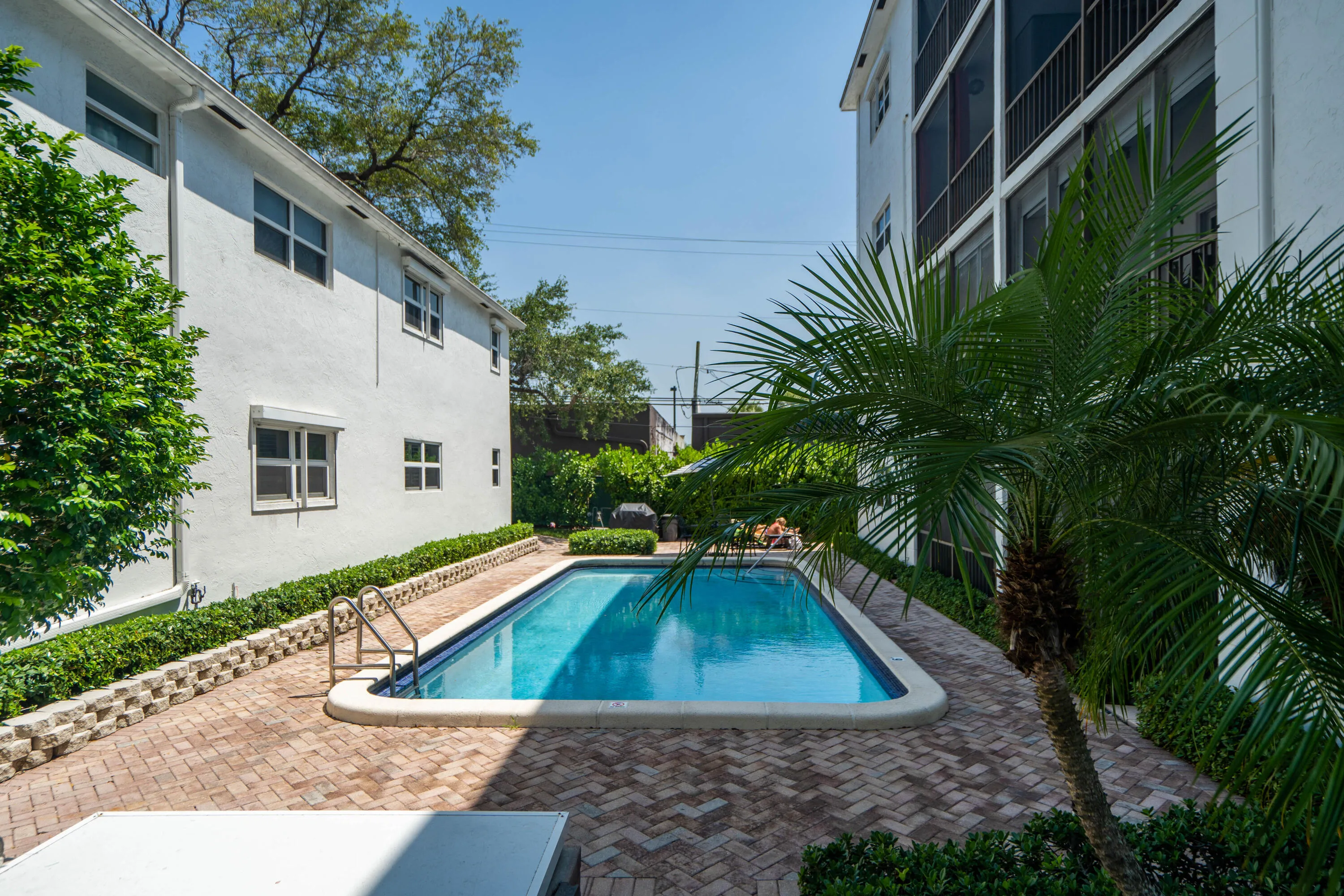 Rectangular swimming pool with integrated steps, surrounded by a brick paver deck