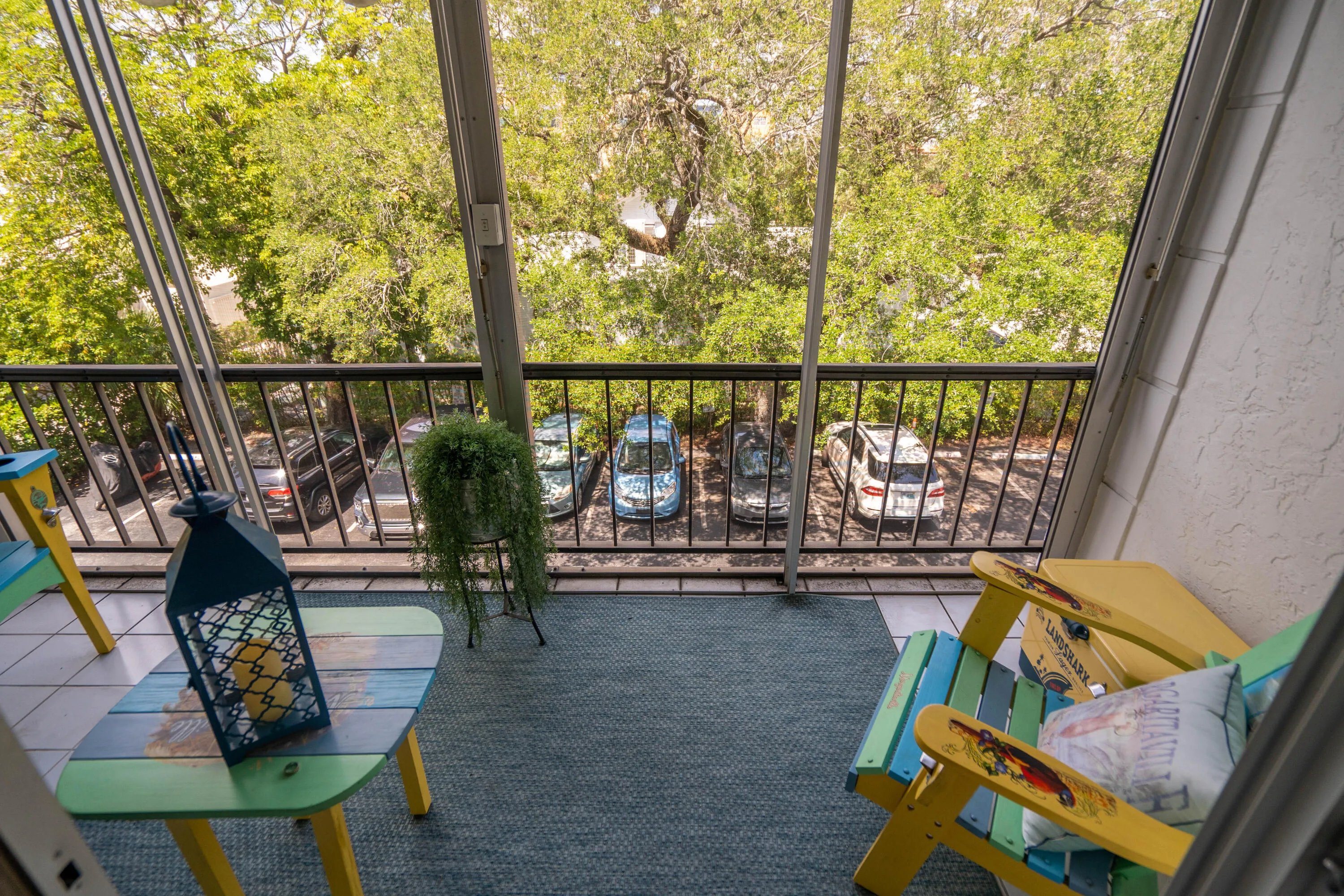 Enclosed balcony featuring a tiled floor, textured exterior wall, and metal railing