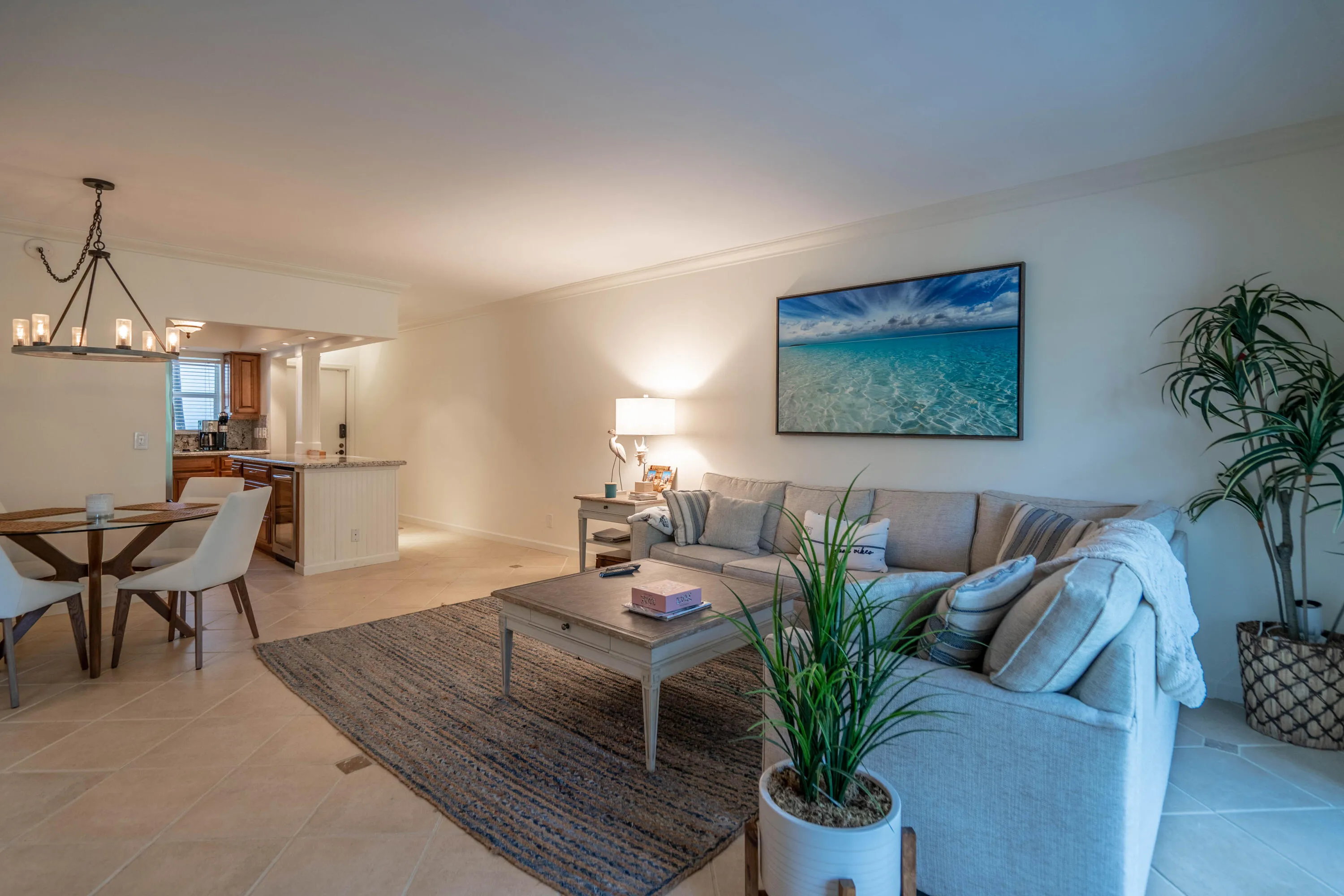 Open-concept living area featuring tile flooring, crown molding, and recessed lighting
