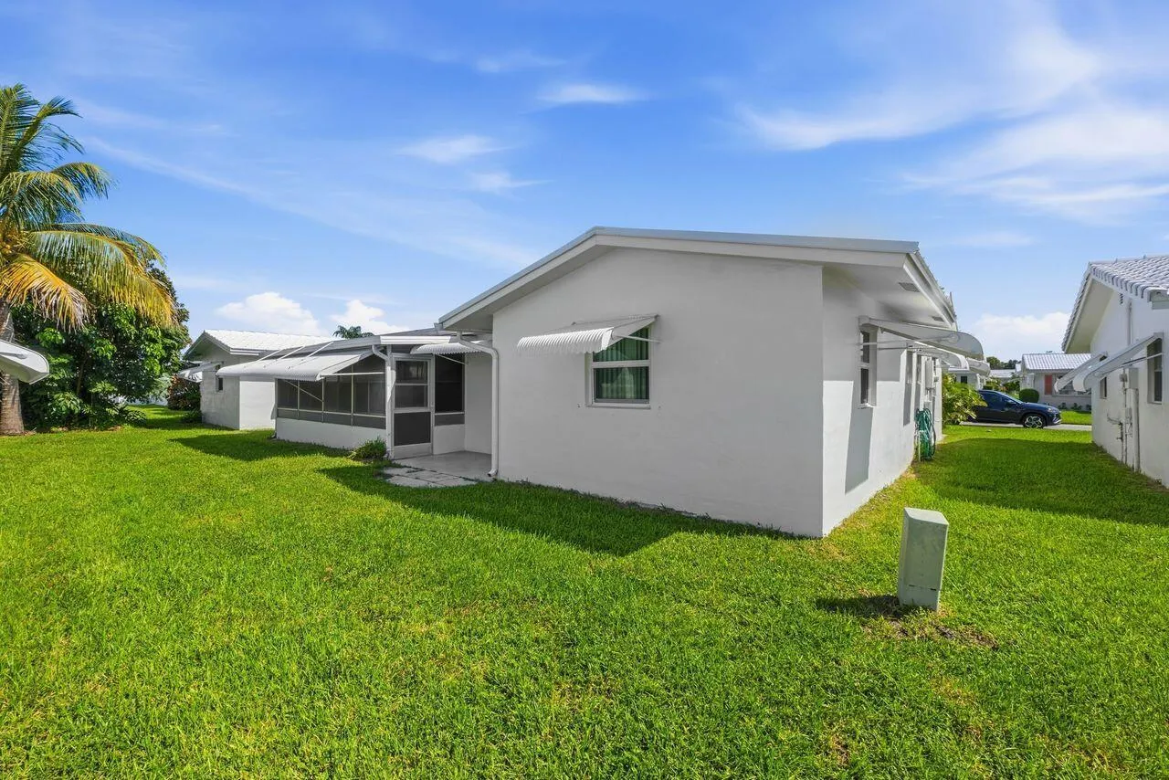 Expansive grassy area with an screened in patio