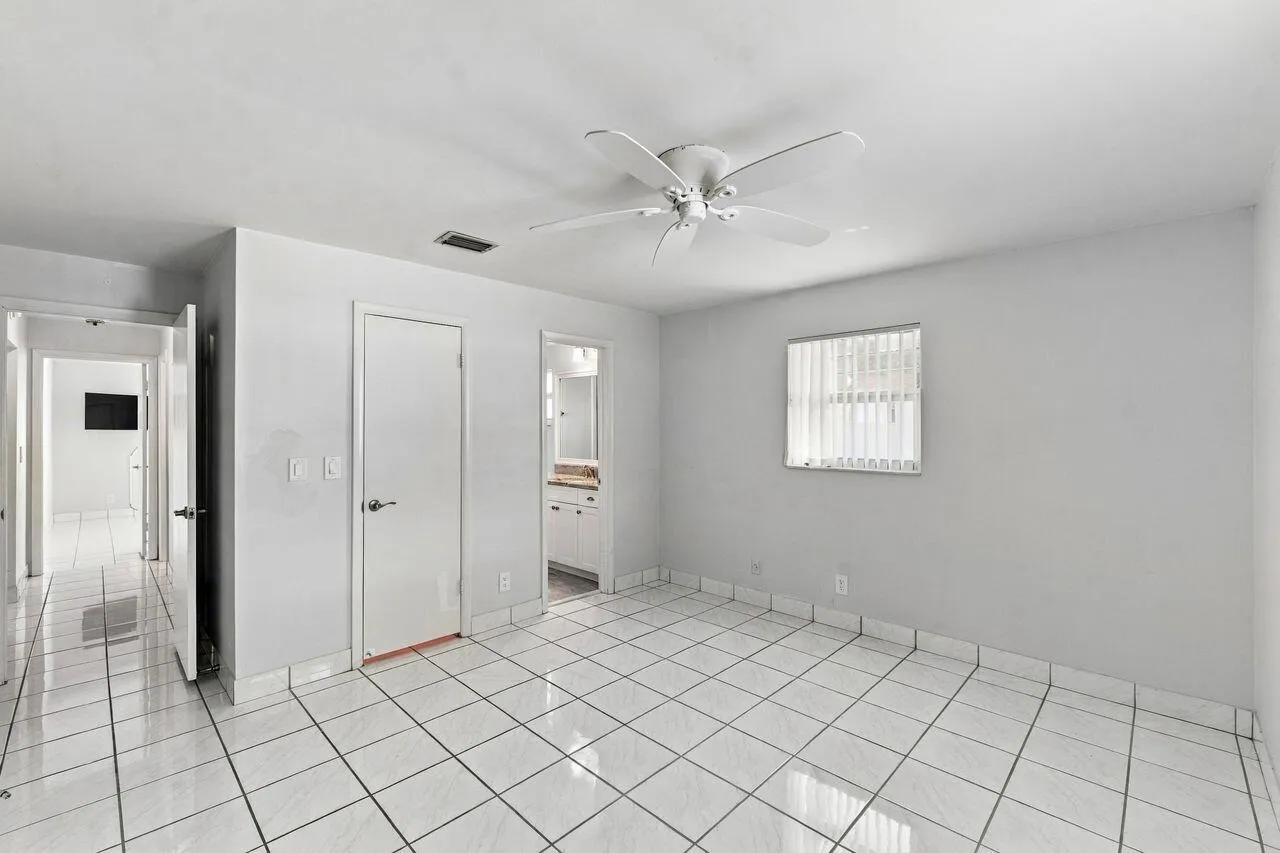 White tile flooring, ceiling fan, white paneled doors, and lots of light