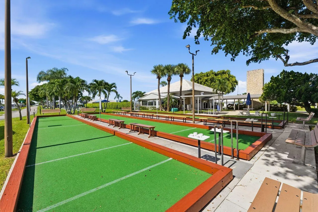 Bocce ball courts with synthetic turf surfaces, bordered by wood-finish retaining walls and integrated seating