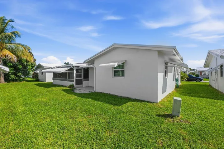Expansive grassy area with an screened in patio