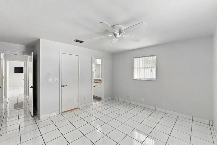 White tile flooring, ceiling fan, white paneled doors, and lots of light