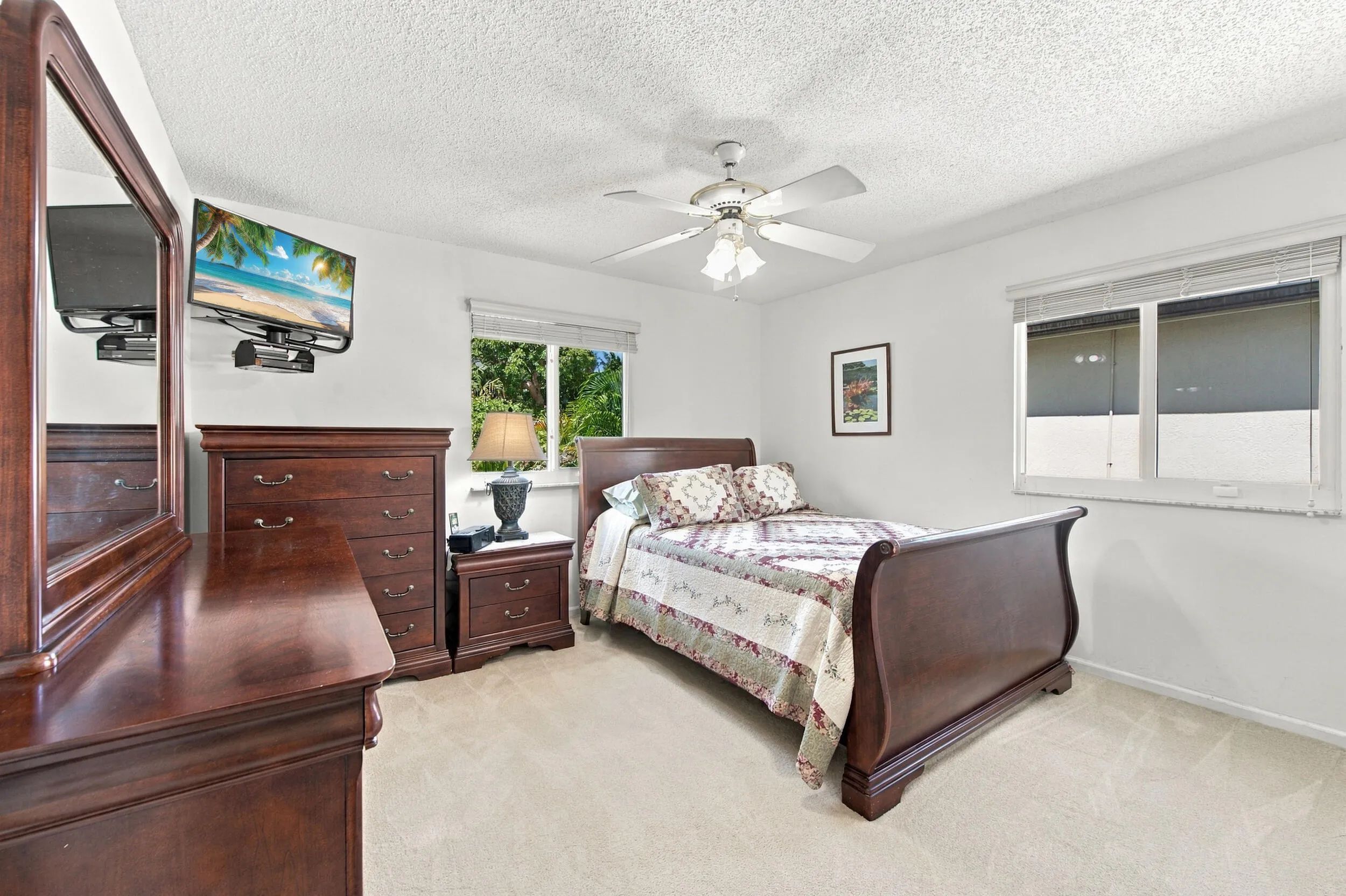 Recessed windows with blinds, carpeted flooring, and a ceiling fan with integrated lighting