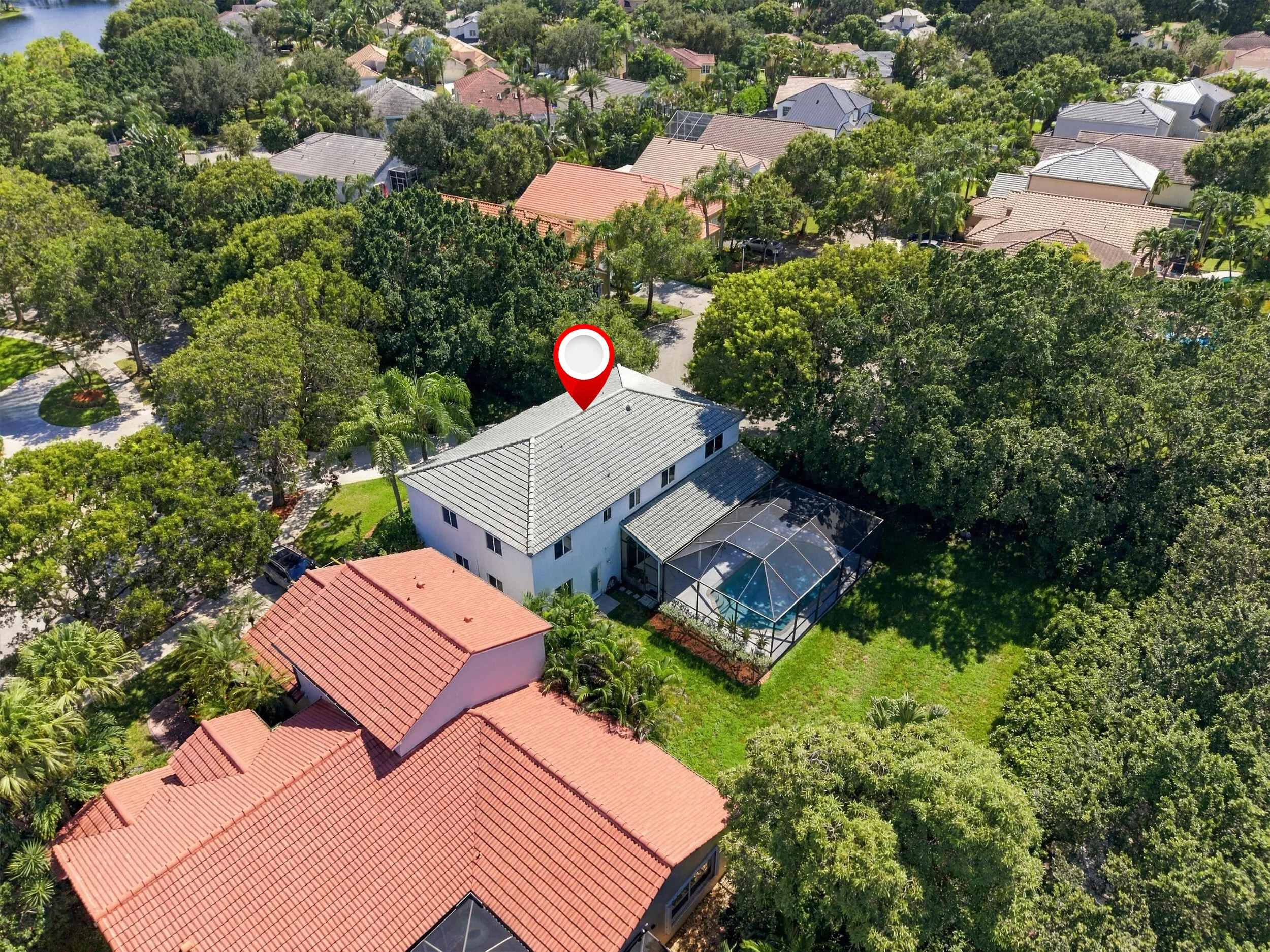 Two-story residence with a screened pool enclosure and mature trees