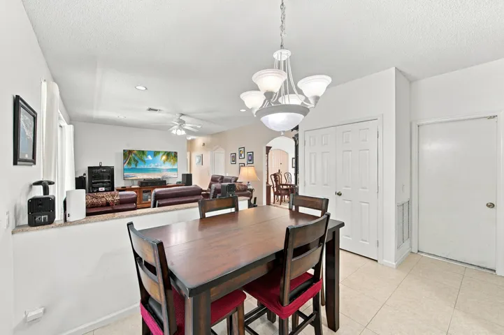 Tiled flooring, overhead chandelier, recessed lighting, and a ceiling fan