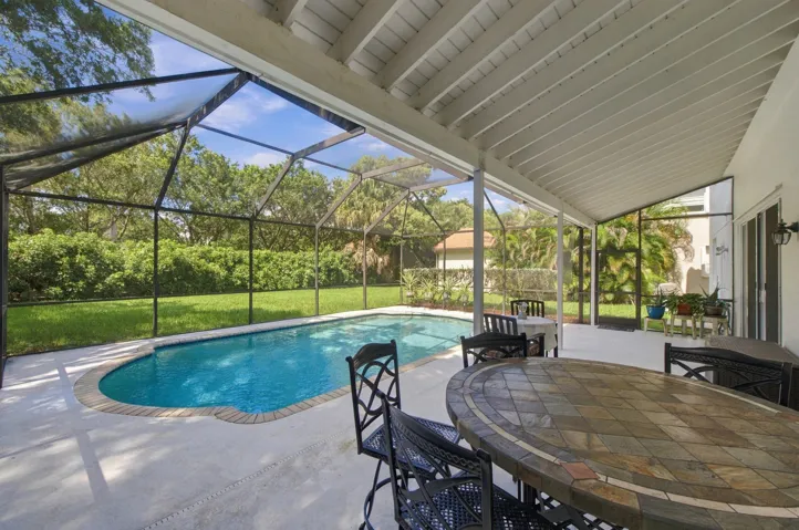 Screened patio featuring a swimming pool, covered outdoor living space, and a tiled outdoor dining table